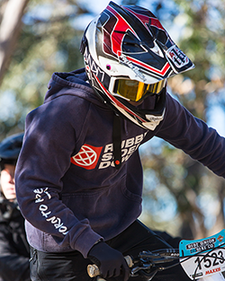 Rider in a navy Rubber Side Down hoodie and full face helmet at a race round
